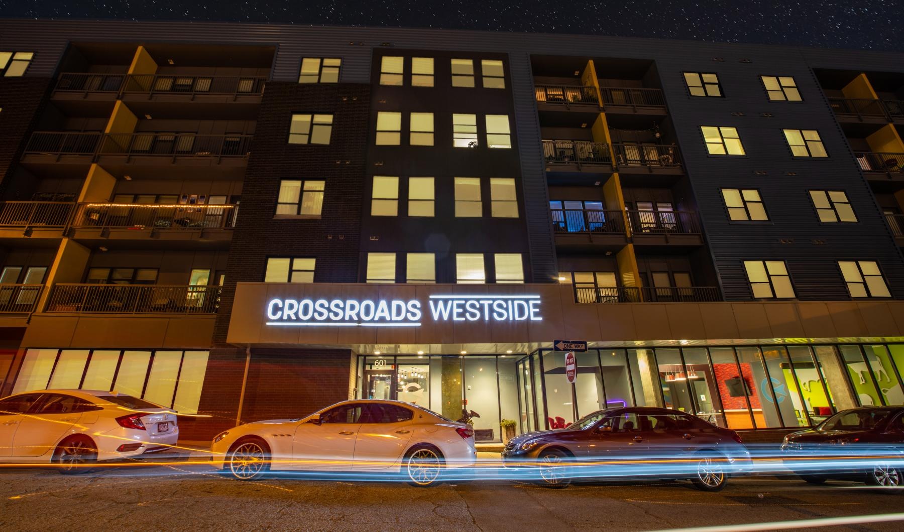 Settle into comfort at Crossroads Westside a building with cars parked in front